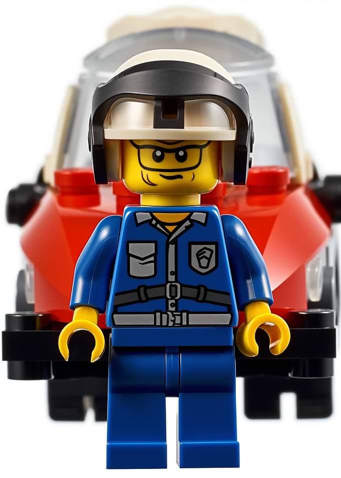 Lego minifigure in front of a car