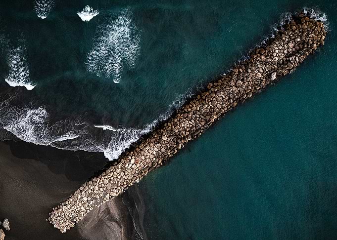 Aerial View of a Stone Jetty and Waves