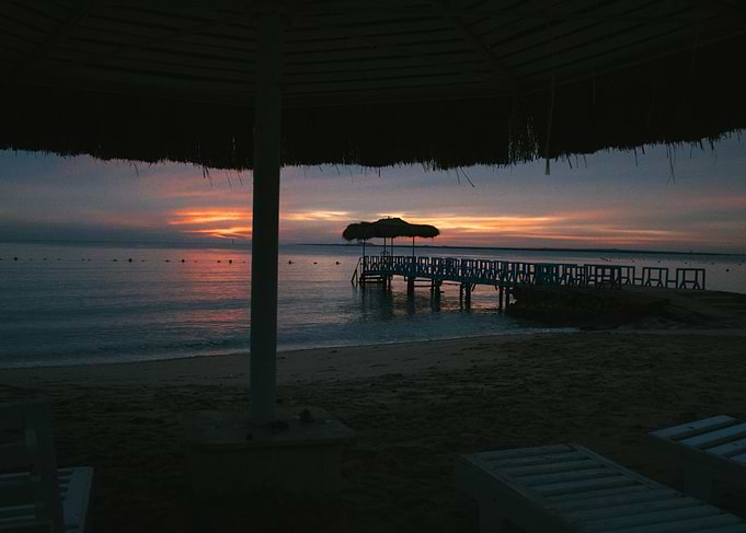 Sunset over the ocean with a pier