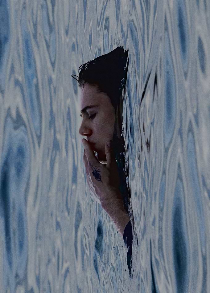 Woman submerged in water with spider tattoo