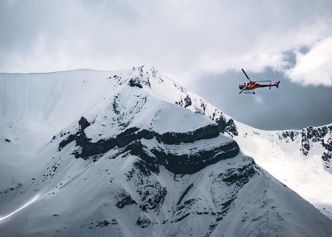Helicopter flying over snowy mountains