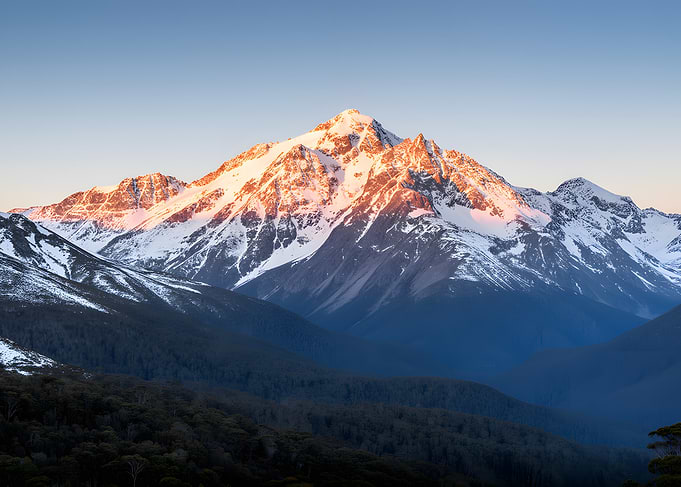 Snow-capped mountain peak at sunrise