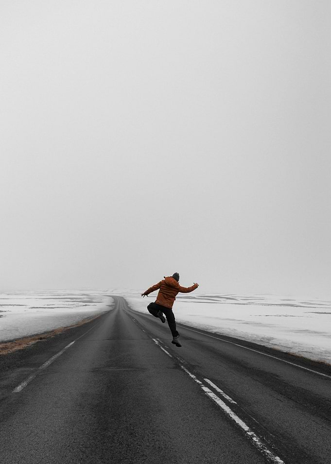 Man jumping on a snowy road