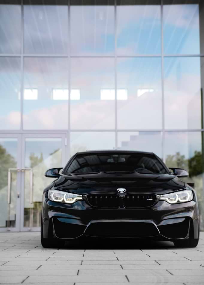 Black BMW M4 parked outside modern building