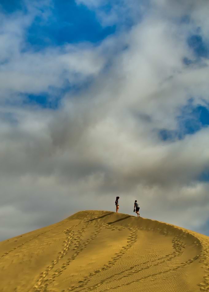 Two people on a sand dune