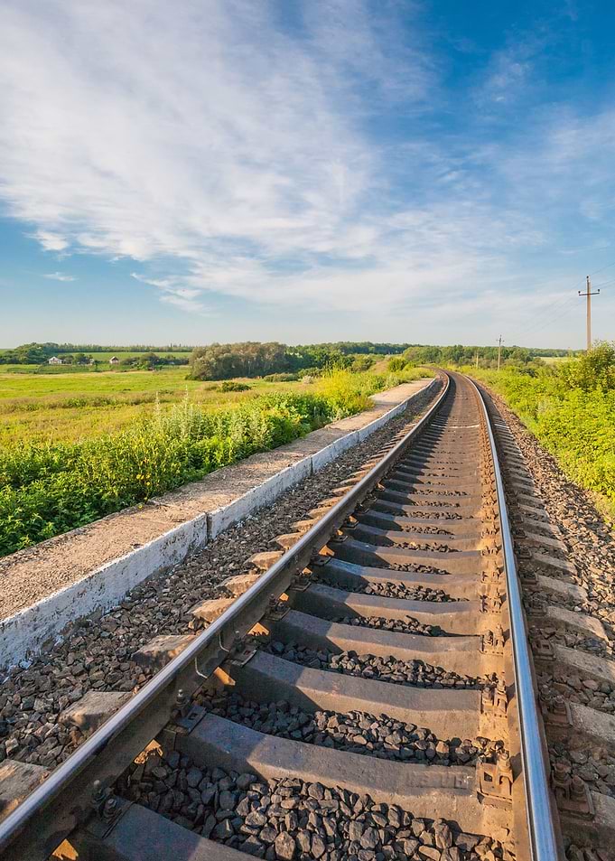 Railway tracks curving through a green landscape