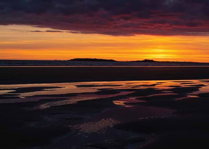 Sunset over a beach with tide pools