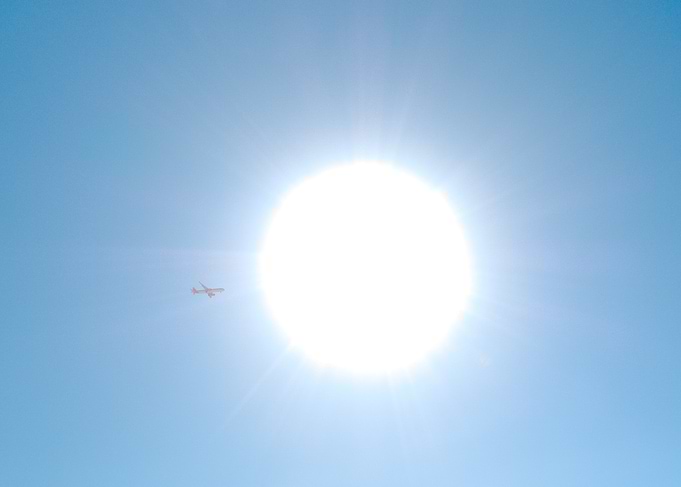 Airplane flying near the sun