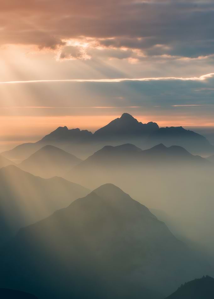 Dawn Over the Peaks – Golden Light Through Misty Mountain