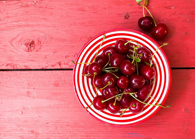 Cherries in a Red and White Striped Bowl