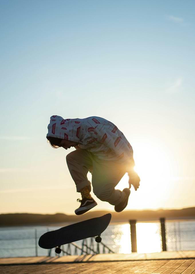 Skateboarder mid-air jump at sunset