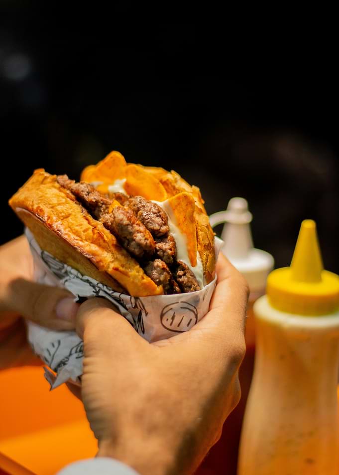 Person holding a loaded burger