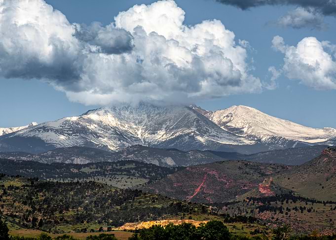 Snow-capped Mount Meeker under dramatic clouds