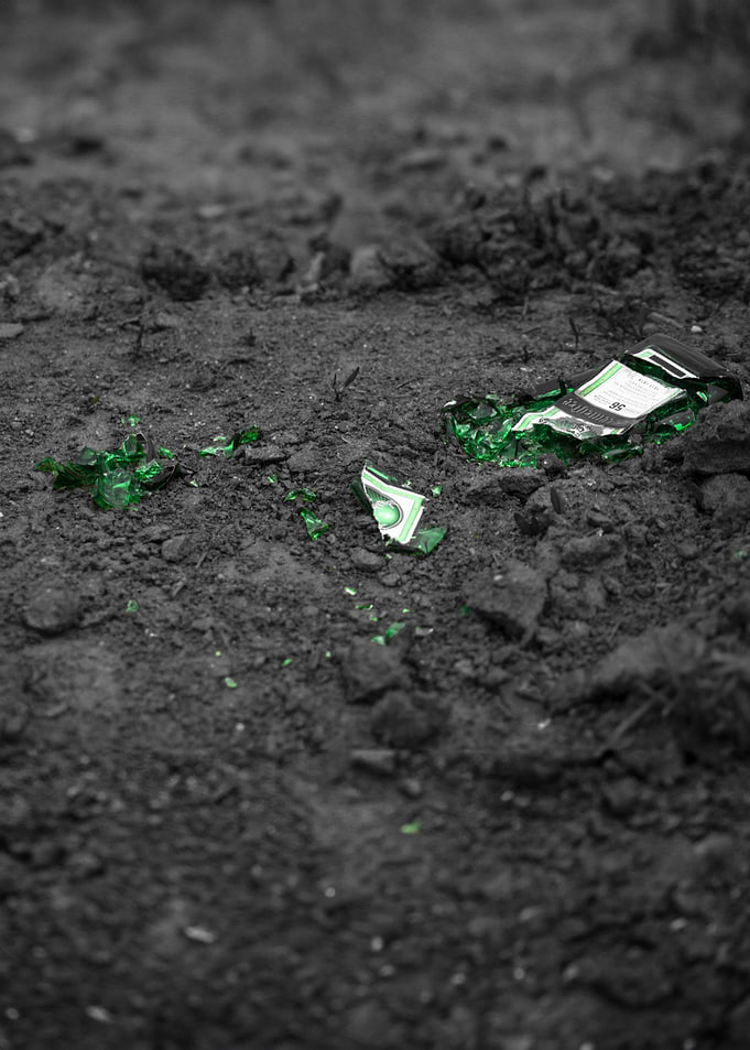 Shattered Green Bottle on Dark Soil