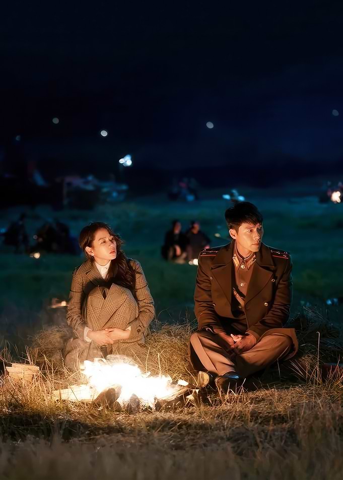Couple by campfire at night