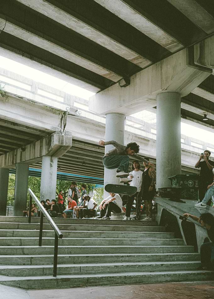 Skateboarder mid-air jump under bridge