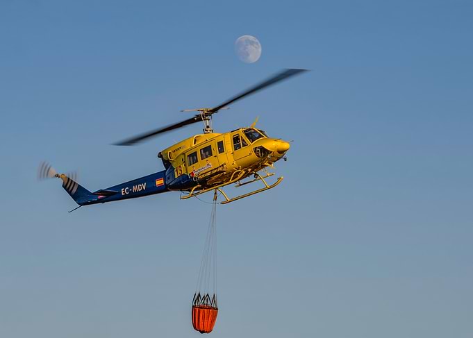 Yellow helicopter with water bucket