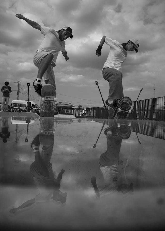 Skateboarders performing tricks with reflections