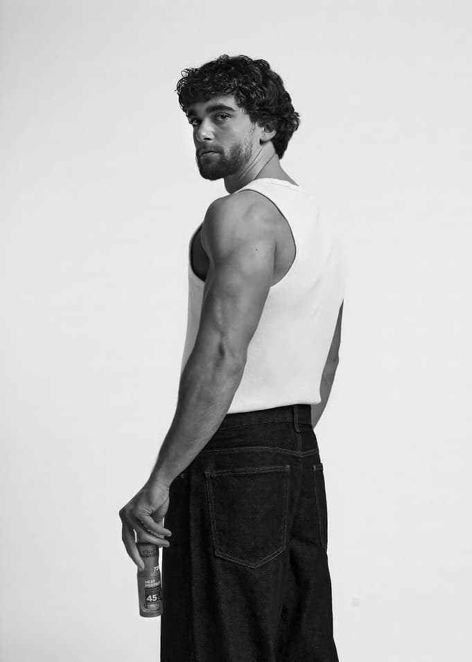 Man in Tank Top and Jeans Holding Bottle