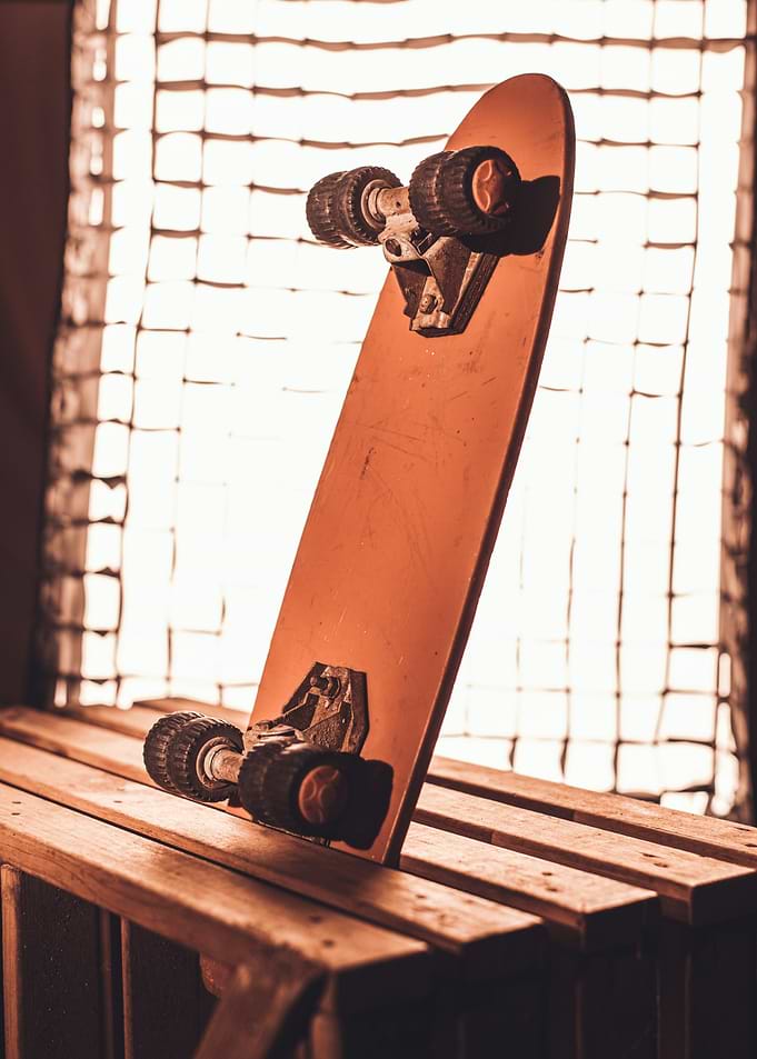 Orange Skateboard on Wooden Slats