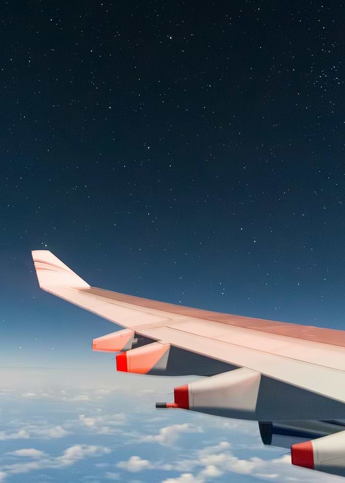 Airplane wing against starry night sky