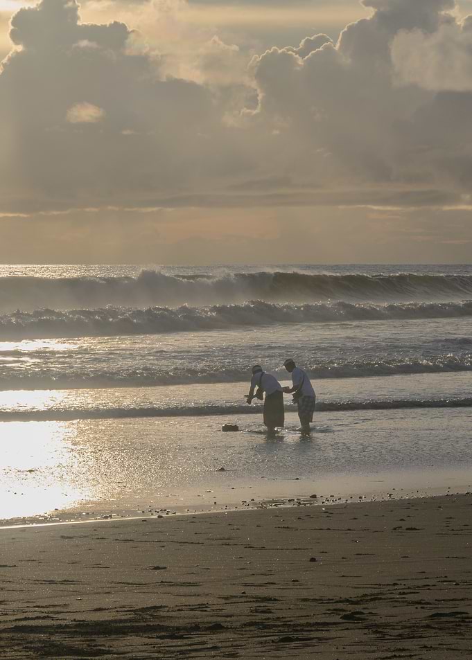 Two people on a beach at sunset
