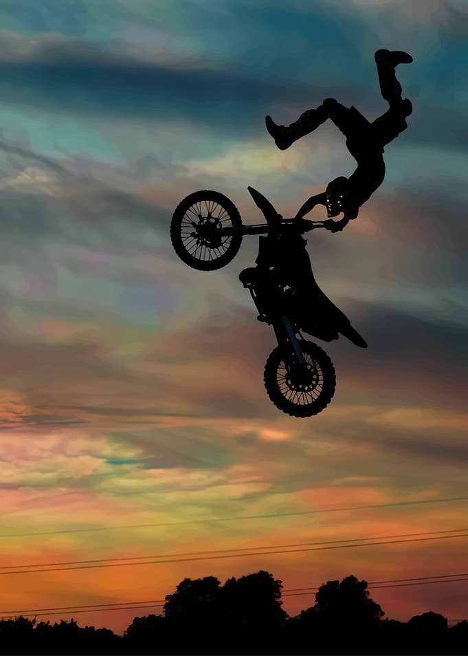 Motocross rider performing a stunt at sunset