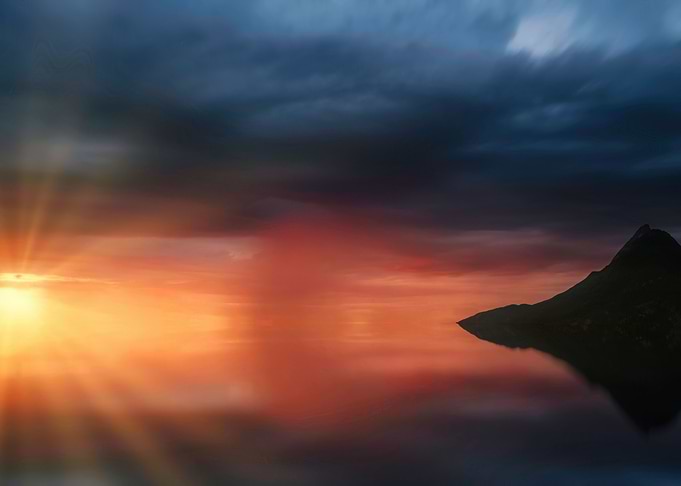 Dramatic Sunset Over Water with Mountain