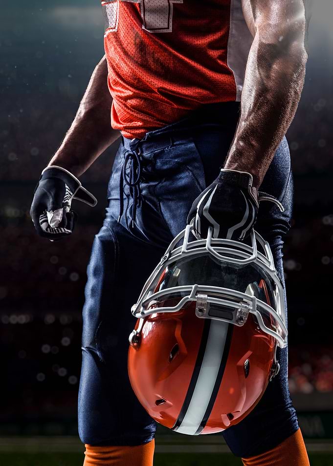 American Football Player Holding Helmet