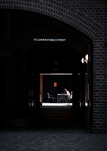 Person sitting at a table in an archway