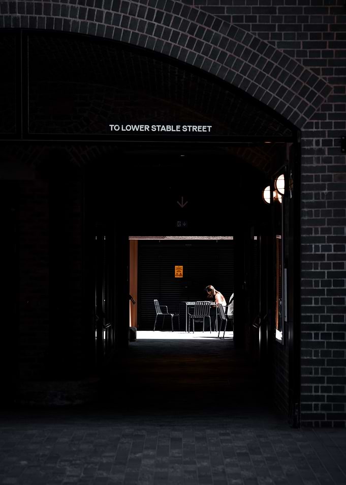 Person sitting at a table in an archway