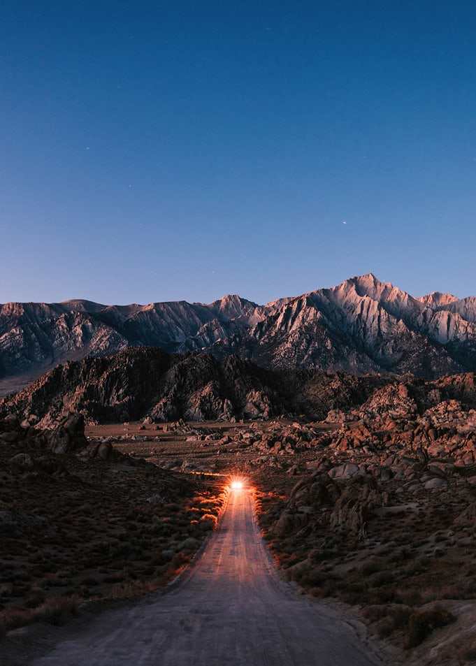 Road leading to mountains at dusk