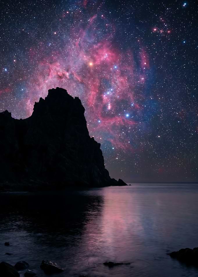 Cosmic Nebula Over Rocky Coastline