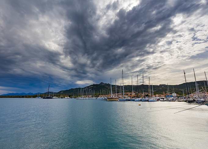 Sailboats in a Harbor Under Stormy Skies