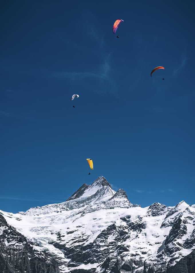 Paragliders over snowy mountains