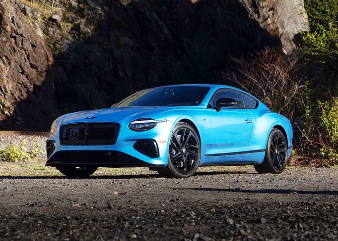 Blue Bentley Continental GT on a Gravel Road