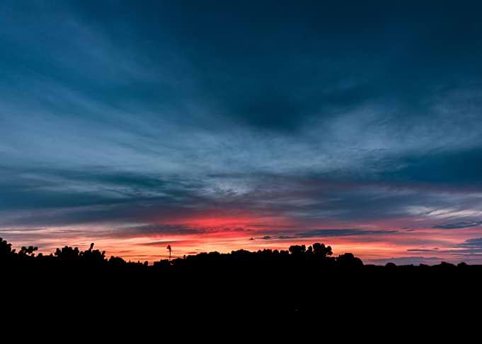 Dramatic Sunset Over Silhouetted Landscape