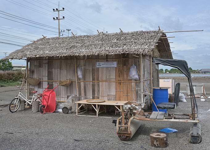 Rustic bamboo hut with farming equipment