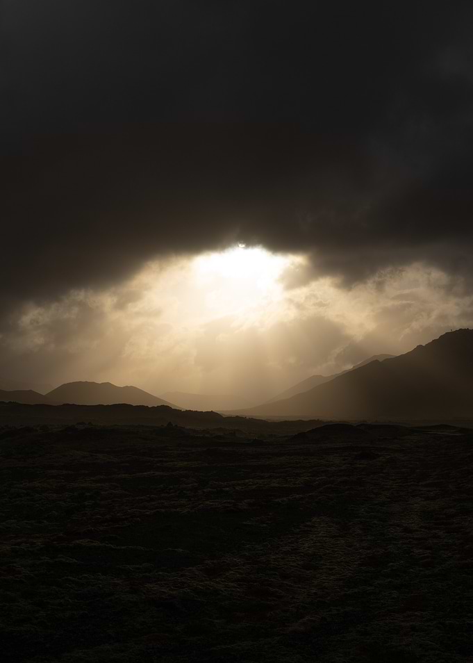 Dramatic Sunbeams Through Stormy Clouds Over Mountains