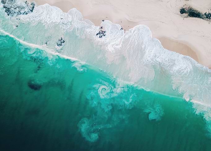 Aerial View of Turquoise Ocean Waves Crashing on Sandy Beach
