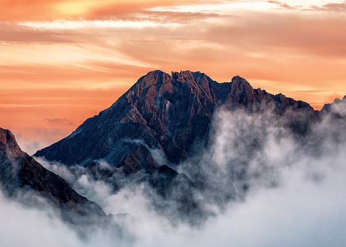 Mountain peak at sunset with clouds