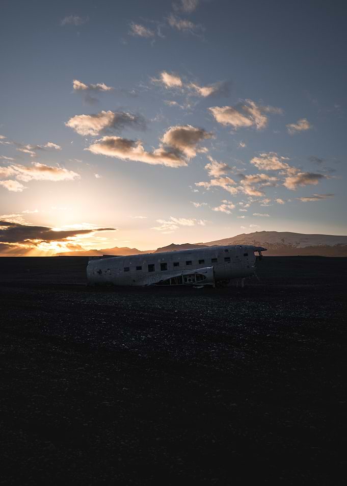 Crashed plane on a Black Sand Beach at Sunset