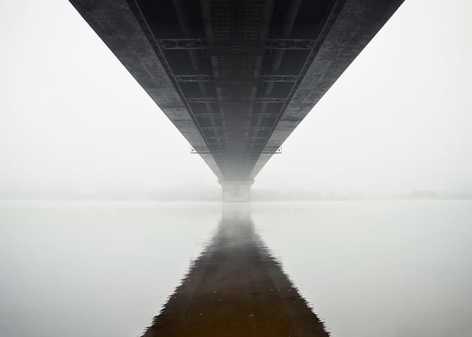 Bridge Reflection in Foggy Water