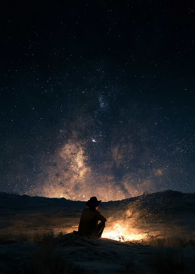 Cowboy under the stars by campfire