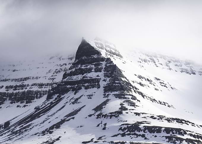 Snow-covered mountain peak in fog