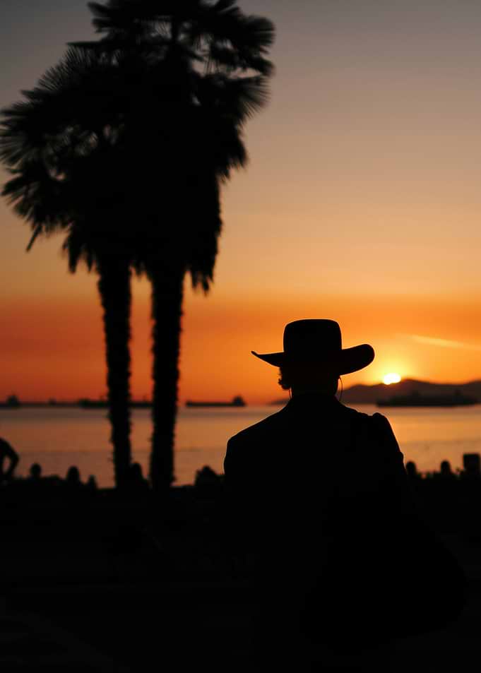 Silhouette of a person in a cowboy hat at sunset