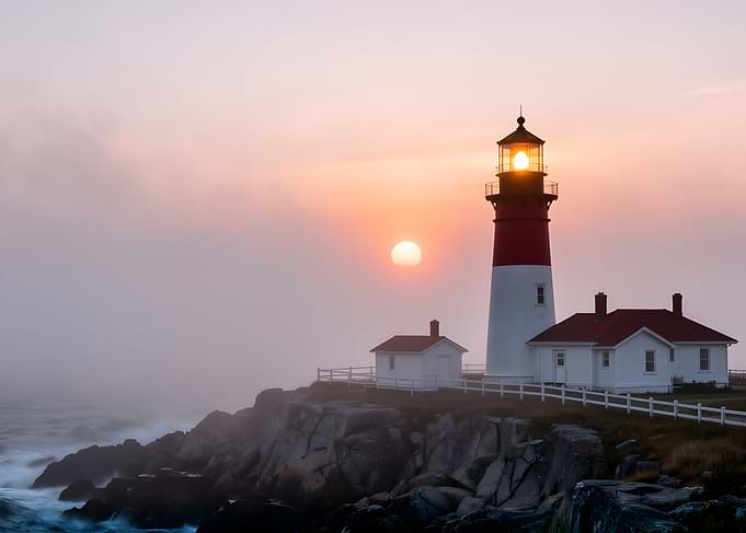 Lighthouse at sunrise with fog