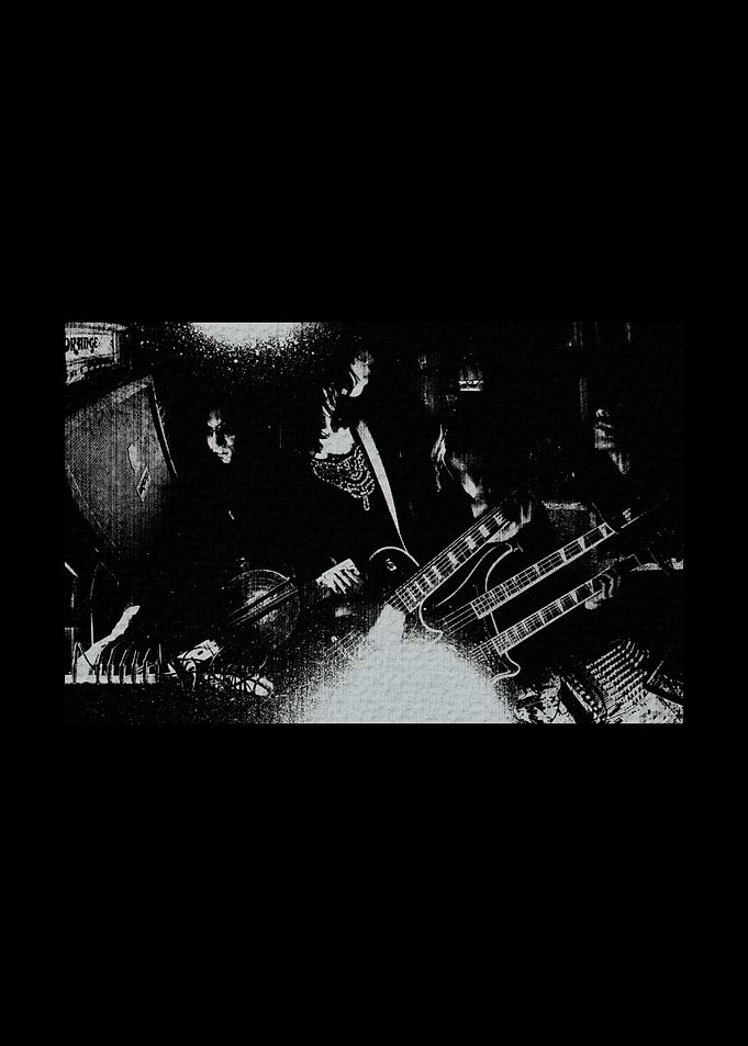 Band playing guitars in a dark setting