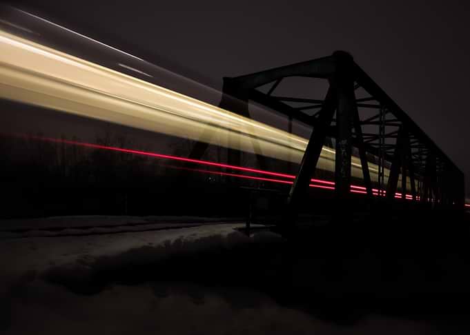 Train light trails over bridge at night