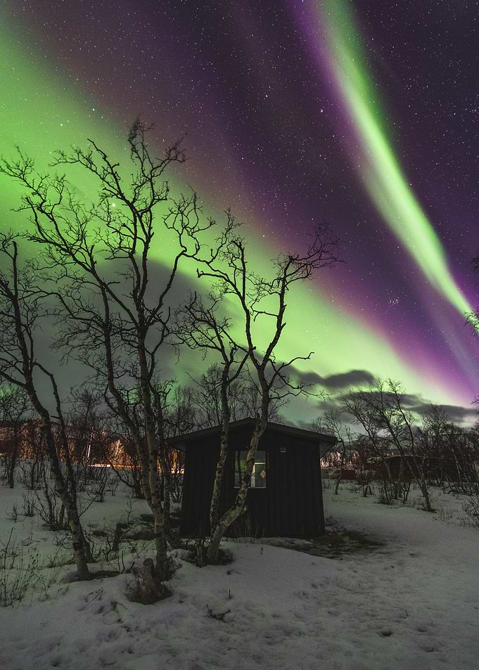 Aurora Borealis over a Snowy Cabin